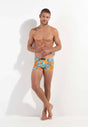 Full-body view of a men model wearing HO orange print  Swim Shorts