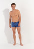 Full-body view of a men model wearing HO navy print  Swim Shorts