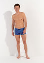 Full-body view of a men model wearing HO navy print  Swim Shorts